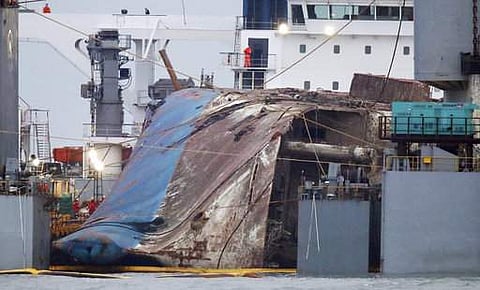 The sunken Sewol ferry is loaded onto a semi-submersible transport vessel during the salvage operation in waters off Jindo, South Korea. (Photo | AP)