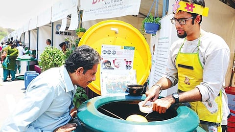 A man checks out a natural compost making process at an exhibition  outside Vidhana Soudha in Bengaluru on Monday | NAGESH POLALI