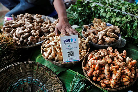 An advertisement board displaying a QR code for Paytm, a digital wallet company, is seen placed amidst vegetables at a roadside vendor's stall in Mumbai (File | Reuters)