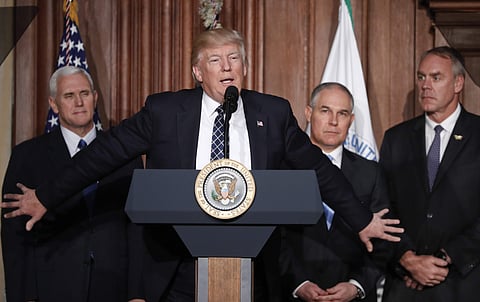 In this Tuesday, March 28, 2017 file photo, President Donald Trump, accompanied by from left, Vice President Mike Pence, Environmental Protection Agency (EPA) Administrator Scott Pruitt, and Interior Secretary Ryan Zinke, speaks at EPA headquarters in Was