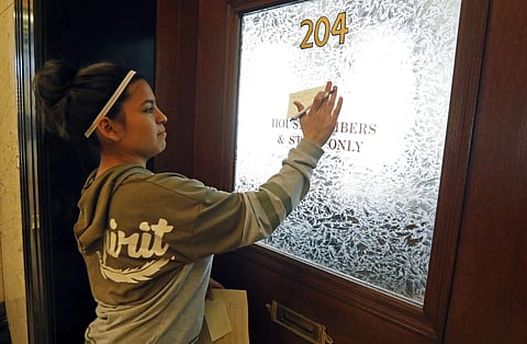Diana Hodges places a sticky note that calls for freeing 22-year old Daniela Vargas, a Argentine native who has lived in the United States since she was seven years old, on the office doors of lawmakers at the Capitol in Jackson, Miss., Friday, March 3, 2