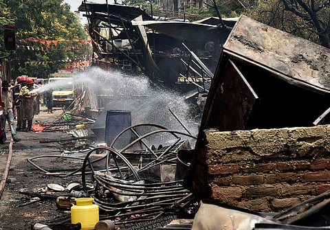 Firemen putting out the fire at Nampally slum beside the Exhibition Grounds in Hyderabad.(Vinay Madapu | EPS)