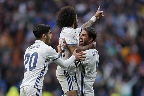 Real Madrid's Marcelo, top, celebrates with teammates Sergio Ramos, right, and Marco Asensio after scoring their side's second goal against Valencia. (AP)