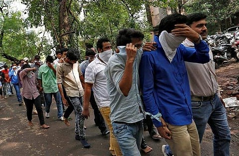 Police escort men who they said were arrested on suspicion of tricking American citizens into sending them money by posing as U.S. tax officials, at a court in Thane. (File photo | Reuters)
