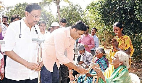 Former cricket captain Anil Kumble distributing walking sticks to the elderly in the Begur village