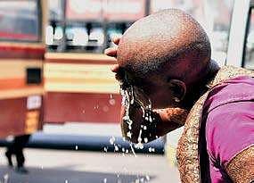A woman splashing water over her face to beat the heat at the CMBT bus terminus in Chennai on Tuesday. A heatwave warning has been issued for the next two days | P Jawahar