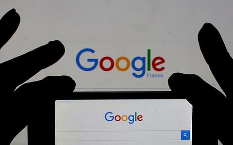 A woman holds her smart phone which displays the Google home page, in this picture illustration.  | Reuters
