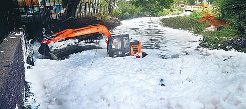 An earthmover pressed into action at Varthur Lake to clear debris and make way for the lake water amidst the toxic foam caused due to pollution in Bengaluru.