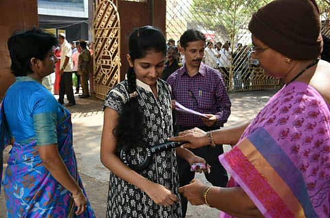 NEET aspirant being checked before entering into the examination centre at Siddhartha public school in Vijayawada. 