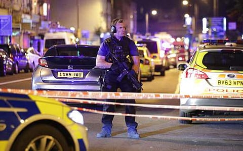An armed police officer mans a cordon on the Seven Sisters Road at Finsbury Park where a vehicle struck pedestrians in London Monday, June 19, 2017.  | AP