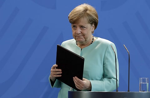 German Chancellor Angela Merkel leaves after a press statement at the chancellery in Berlin, Germany. | AP