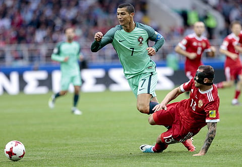 Portugal's Cristiano Ronaldo is tackled by Russia's Fedor Kudriashov during the Confederations Cup, Group A soccer match at the Spartak Stadium in Moscow. | AP