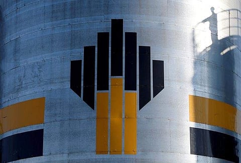 The shadow of a worker is seen next to a logo of Russia's Rosneft oil company at the central processing facility of the Rosneft-owned Priobskoye oil field outside Nefteyugansk, Russia, August 4, 2016. | Reuters