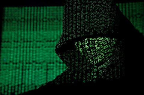 A projection of cyber code on a hooded man is pictured in this illustration picture taken on May 13, 2017. Reuters