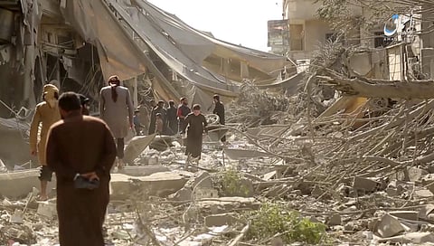 This undated frame grab from video posted online by the Aamaq News Agency, a media arm of the Islamic State group, shows people inspecting damage from airstrikes and artillery shelling in the northern Syrian city of Raqqa. (AP)
