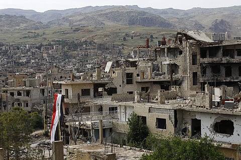 A Syrian National flag hangs out of a damaged building at the mountain resort town of Zabadani in the Damascus countryside, Syria. (File photo | AP)