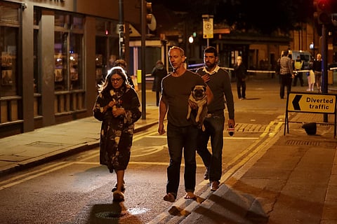 A man carries a dog with a woman wearing a dressing gown after an attack in London, Sunday, June 4, 2017.  (AP)