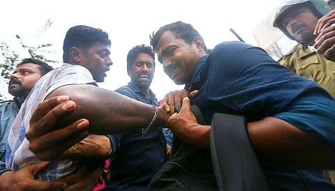 CPM activists attack the New Indian Express photographer, A Sanesh,(blue) and later broke his camera for clicking pictures of the violence that erupted during a hartal in Kozhikode, Kerala. (EPS)