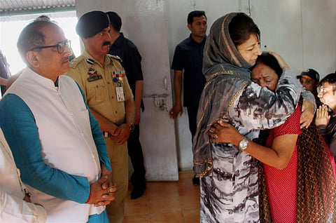 Jammu Kashmir Chief Minister Mehbooba Mufti consoles an Amarnath pilgrim who survived the Anantnag militant attack before she was airlifted to New Delhi at the airport in Srinagar on Tuesday. Dy CM Nirmal Kumar is also seen. (PTI)