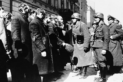 This 1943 file photo shows Nazi officers talking with citizens of the Warsaw ghetto in Poland. (AP Photo, File)