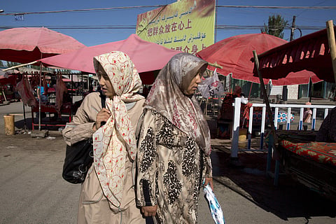 Uighur women in loose, full-length garments and headscarves associated with conservative Islam visit a market in Alaqagha in western China's Xinjiang province in July. (File| AP)
