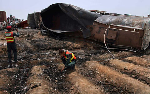 Pakistani rescue workers examine the site of an oil tanker explosion at a highway near Bahawalpur, Pakistan, Sunday, June 25, 2017. (AP Photo/Iram Asim)