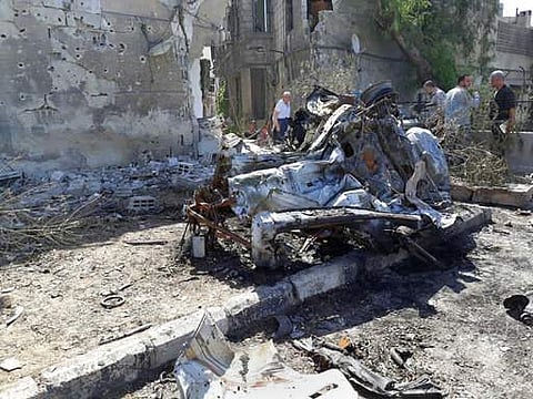 This photo released by the Syrian official news agency SANA, shows people gathering at the scene of an explosion along the road to the airport in southeast Damascus on July 2. (Photo | AP)