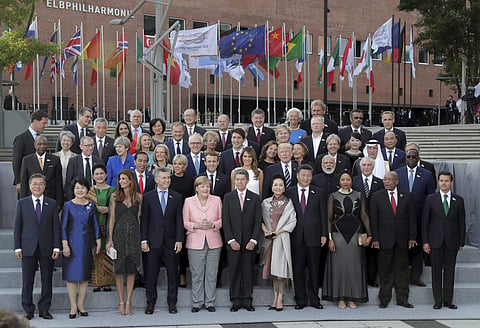 The G-20 participants and their spouses pose for a family photo in front of the Elbphilharmonie concert hall on the first day of the G-20 summit in Hamburg northern Germany Friday July 7 2017.  (AP)
