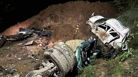 The mangled remains of vehicles after two buses and other passenger vehicles were swept away by a massive landslide at Kotrupi in Mandi district on Saturday night. | PTI