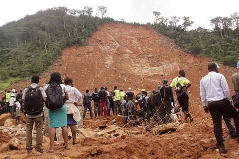 Red Cross volunteers digging for survivors at the scene of heavy flooding and mudslides is seen in the picture. (Photo  | AP)