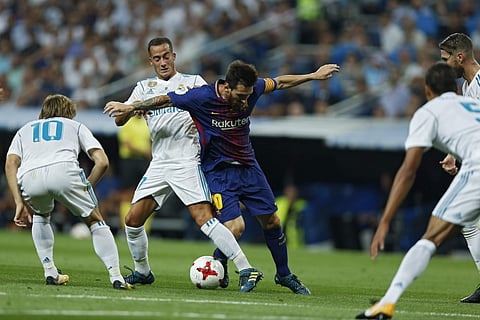 Barcelona's Lionel Messi, right, vies with Real Madrid's Lucas Vazquez, left, during the Spanish Super Cup second leg soccer match between Real Madrid and Barcelona at the Santiago Bernabeu stadium in Madrid, Wednesday, Aug. 16, 2017. | AP