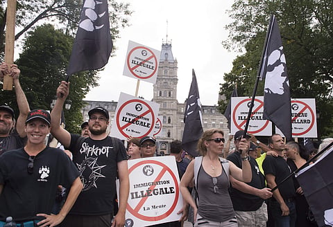Tensions boiled over in Quebec City on Sunday, as police were pelted by beer bottles and smoke bombs set off in garbage cans (AP)