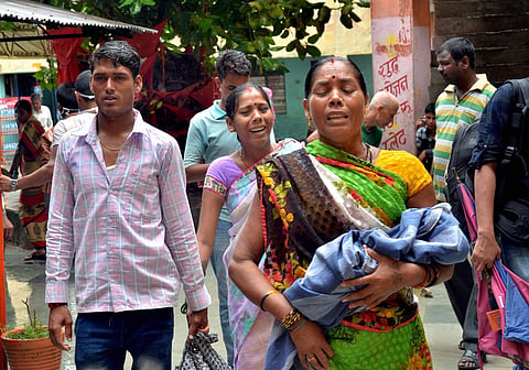 Relatives carry a child at the Baba Raghav Das Medical College Hospital where over 70 children have died. | PTI
