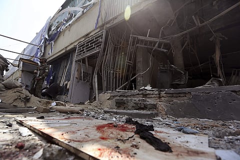 An Afghan security guard stand in front of Kabul Bank after suicide attack in Kabul, Afghanistan, Tuesday, Aug. 29, 2017. The area where the explosion took place, in the center of the Afghan capital, is home to many businesses. | AP