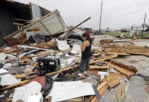 A woman looks over the debris from her family business destroyed by Hurricane Harvey.  (Photo | AP)