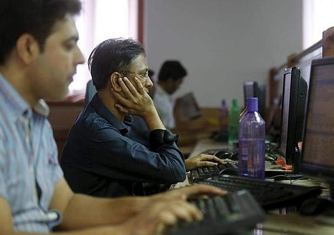 Brokers trade at their computer terminals at a stock brokerage firm in Mumbai. (File photo | Reuters)