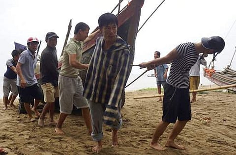 Vietnamese villagers move a fishing boat on shore in northern Thanh Hoa province, Vietnam, Thursday, Sept. 14, 2017.  | AP
