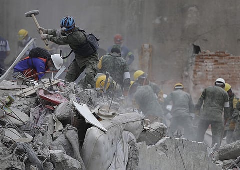 Rescue workers search for survivors at an apartment building located on the street corner of Amsterdam and Laredo, that collapsed during an earthquake in the Condesa neighborhood of Mexico City on Sept. 21, 2017. (Photo | AP)
