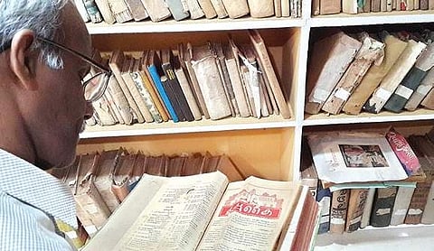 A reader flips through an old issue of a vernacular magazine at the library.