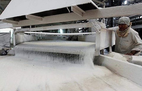 A worker checks the flow of sugar inside the Gandavi sugar factory, 165 km (102 miles) south of Ahmedabad, India, March 26, 2012. REUTERS/Amit Dave/File Photo