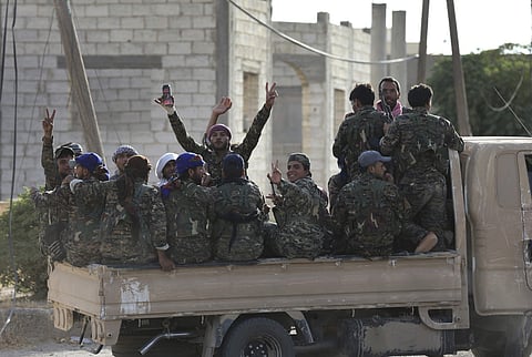 Arab and Kurdish fighters with the U.S.-backed Syrian Democratic Forces (SDF), gather on a pickup as they move to the front line to battle against the IS militants. (AP)