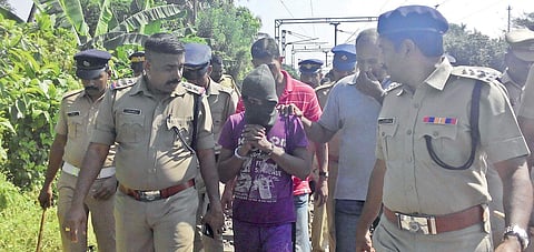 The accused in the robbery case being led through the tracks during collection of evidence