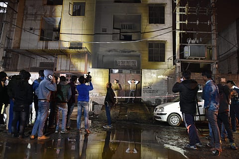 Fire fighters and media outside the two-storey cracker factory which caught fire in north Delhi's Bawana Industrial Area on Saturday. | PTI