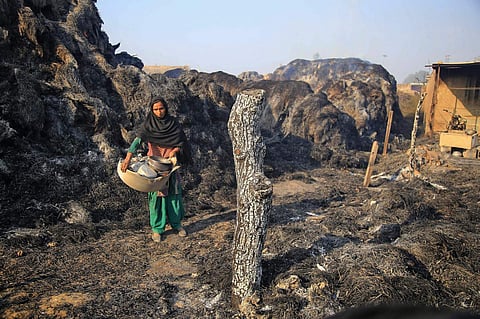 A woman collects all her belongings at a temporary shed damaged in the cross-border shelling by Pakistan at the international border in Jammu. (File | PTI)