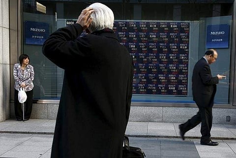 A man looks at an electronic board showing market indices outside a brokerage in Tokyo, Japan, March 2, 2016. (Reuters)