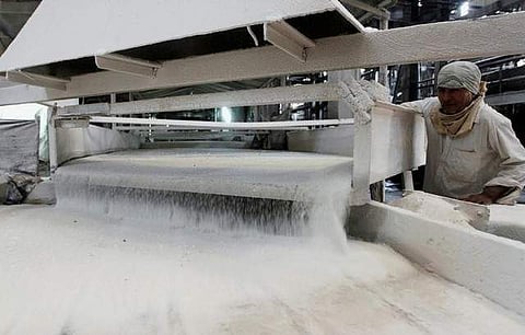 FILE PHOTO: A worker checks the flow of sugar inside the Gandavi sugar factory, 165 km (102 miles) south of Ahmedabad, India, March 26, 2012. | Reuters