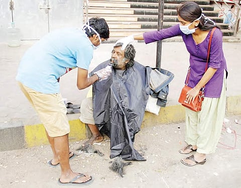 Members of Youngistaan Foundation, an NGO shaving the beard of a beggar on a pavement in Hyderabad on Sunday | Express