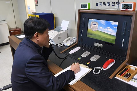 A South Korean government official communicates with a North Korean officer during a phone call on the dedicated communications hotline. (Photo | AP)