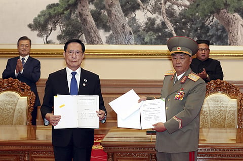 In this Sept. 19, 2018, file photo, South Korea's Defense Minister Song Young-moo, front left, and North Korea's Minister of the People's Armed Forces No Kwang Chol, front right, hold the documents after signing as South Korean President Moon Jae-in, rear