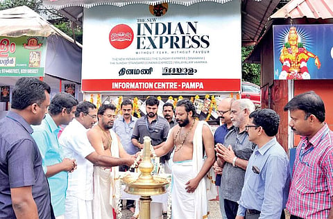 Travancore Devaswom Board president A Padmakumar lighting the lamp marking the inauguration of the information centre of The New Indian Express at Pampa on Monday | Shaji Vettipuram